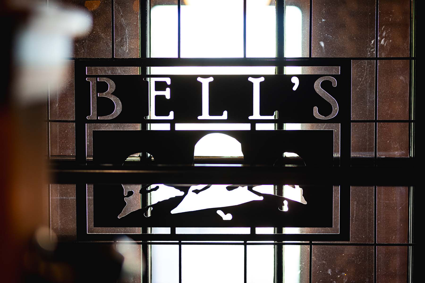 bells sign in black metal over window